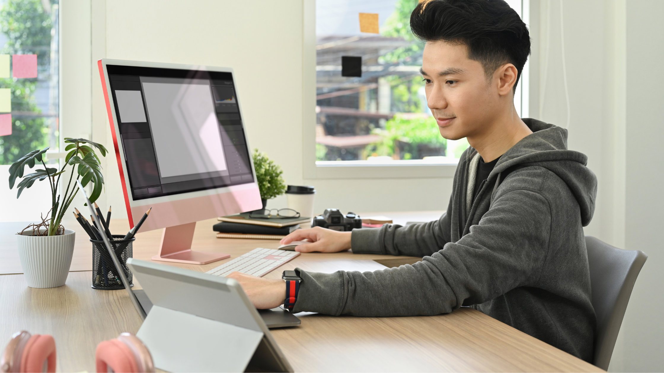 A sitting man working on a video production project on his desktop